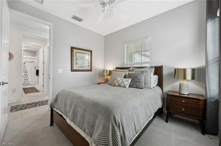 Bedroom with connected bathroom, ceiling fan, and carpet floors