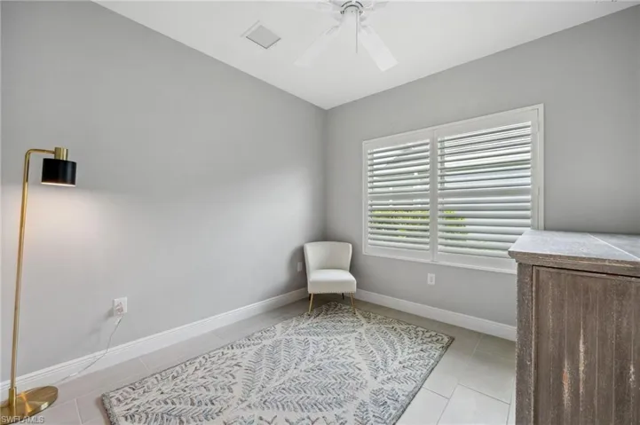Sitting room featuring ceiling fan and light tile floors