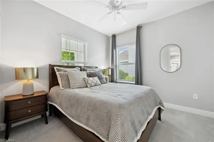 Bedroom with carpet flooring, ceiling fan, and multiple windows
