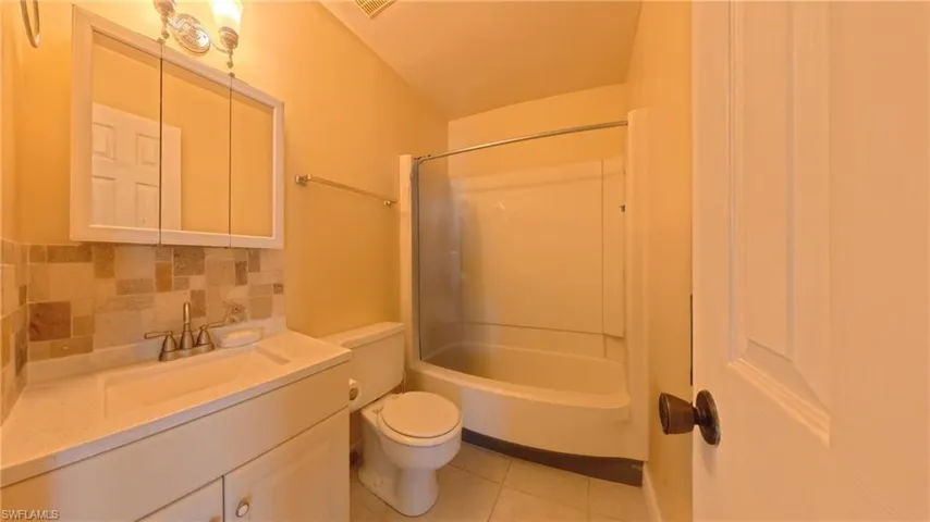 Hall with light tile patterned floors and baseboards