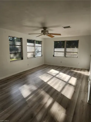 Unfurnished room with ceiling fan and hardwood / wood-style floors