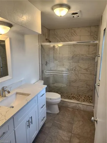 Bathroom featuring vanity, toilet, and walk in shower