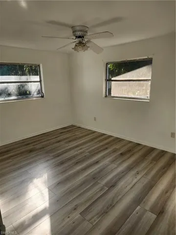 Spare room featuring ceiling fan and dark wood-type flooring