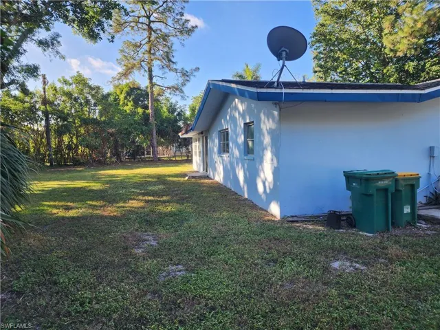 View of side of home with a yard