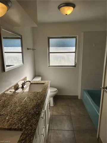 Full bathroom featuring tile patterned flooring, vanity, toilet, and shower / bathing tub combination