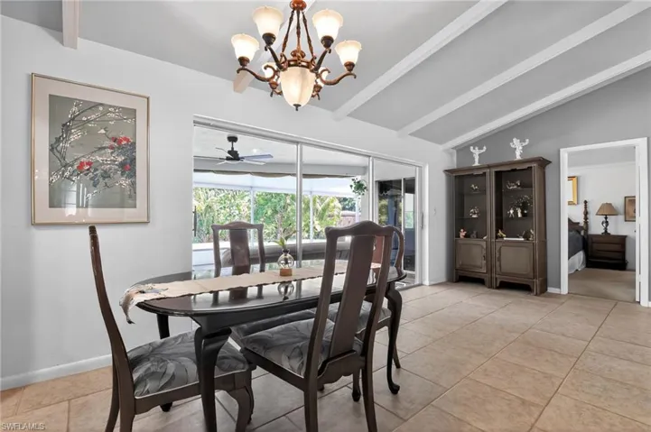 Dining space featuring light tile patterned flooring, a chandelier, and ceiling fan