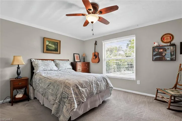 Carpeted bedroom with ornamental molding and ceiling fan