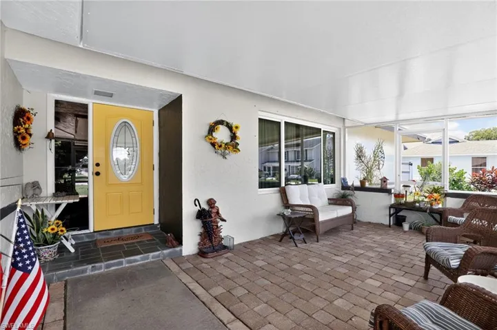 View of exterior entry with a sunroom and stucco siding