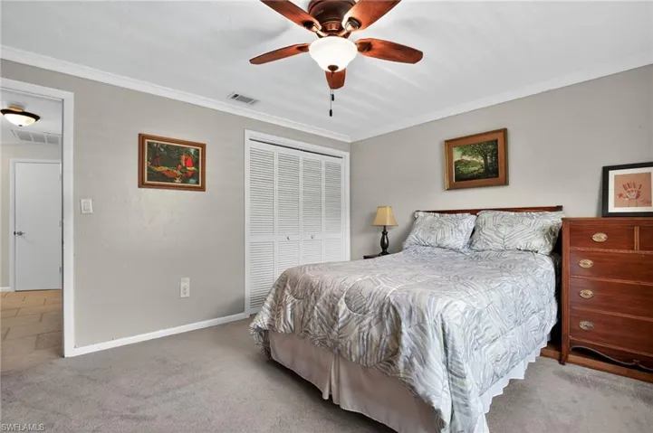 Bedroom featuring carpet floors, crown molding, ceiling fan, and a closet