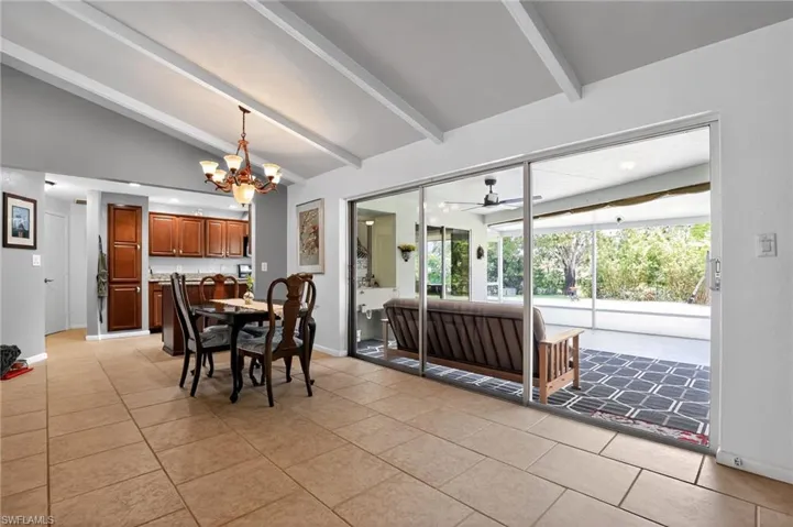 Dining space featuring a ceiling fan, light tile patterned floors, and a chandelier