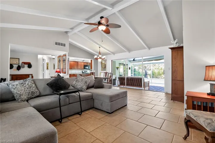 Living area featuring high vaulted ceiling, beam ceiling, a chandelier, ceiling fan, and light tile patterned floors