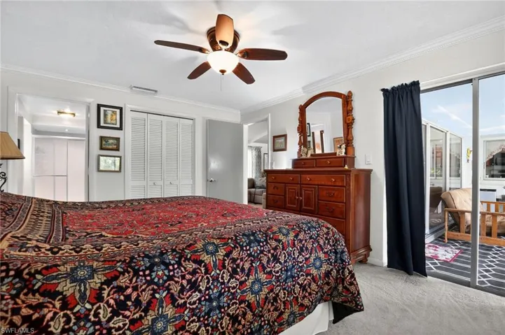 Bedroom featuring crown molding, access to outside, light colored carpet, ceiling fan, and a closet