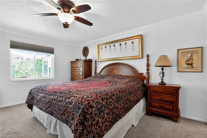 Bedroom featuring crown molding, light colored carpet, and ceiling fan