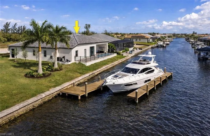 Dock featuring a patio area, a lawn, a water view, and a lanai/ VIRTUALLY STAGED