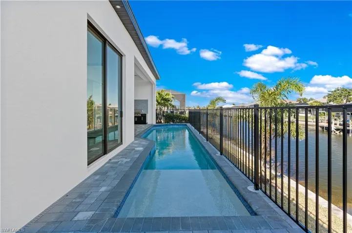 View of swimming pool with a water view and patio surround