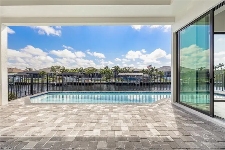 View of pool featuring patio surround, a water view, and a residential view