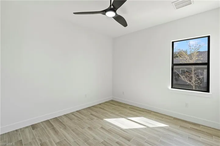 Empty room with wood tiled floors and ceiling fan