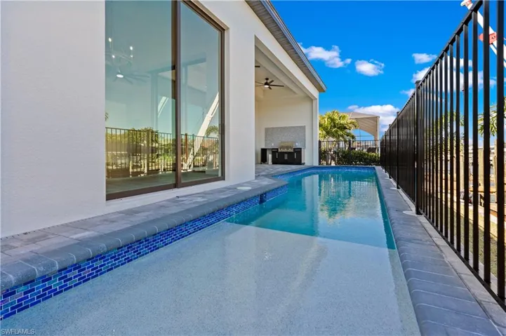 View of pool featuring patio surround and exterior kitchen