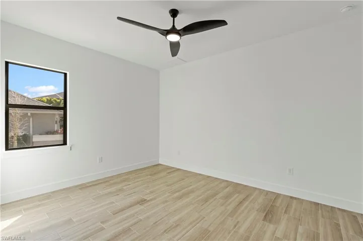 Unfurnished room with wood finish floors and ceiling fan