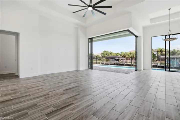 Spare room with wood tiled floors, a ceiling fan, and a high tray ceiling