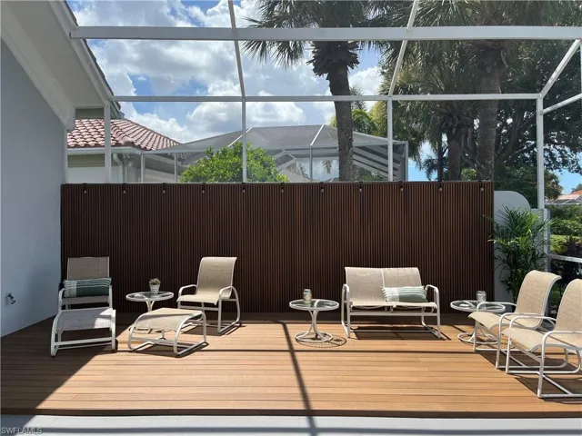 Engineered slatted wood privacy wall w/stringlights and raised deck
