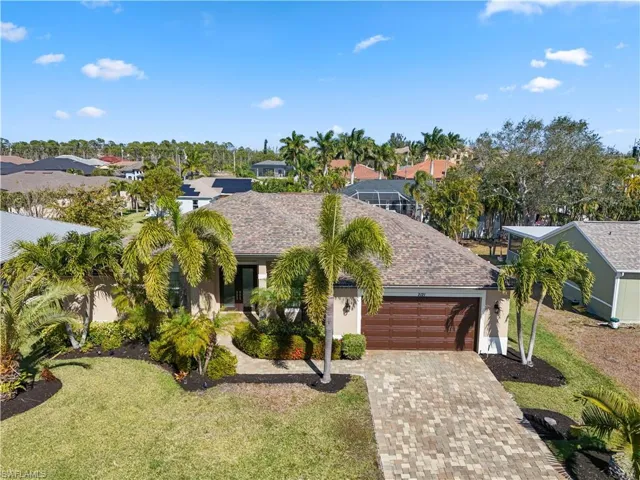 View of front of home with driveway, roof with shingles, a residential view, and a front yard