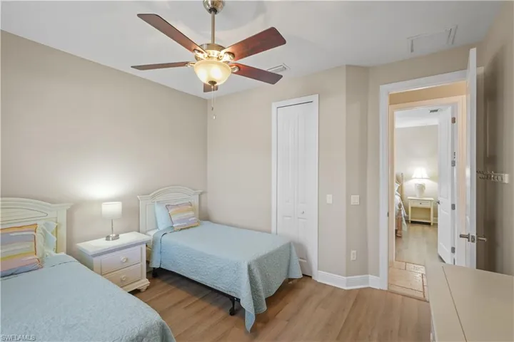 Bedroom with light wood-type flooring, a closet, and a ceiling fan