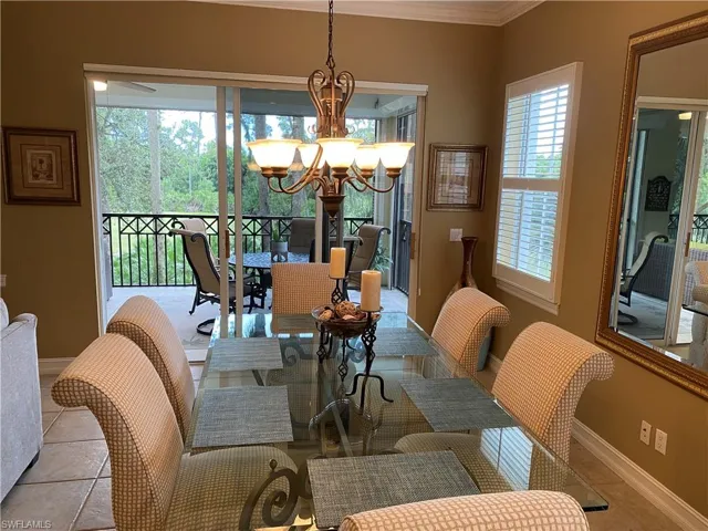 Tiled dining space with suspended lighting and ornamental molding