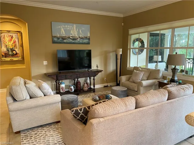 Tiled living room with ornamental molding and baseboards