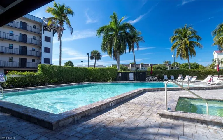 Community pool with a patio area and a hot tub