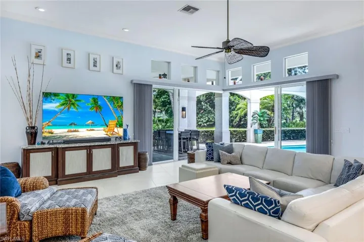 Tiled living room with ornamental molding and ceiling fan