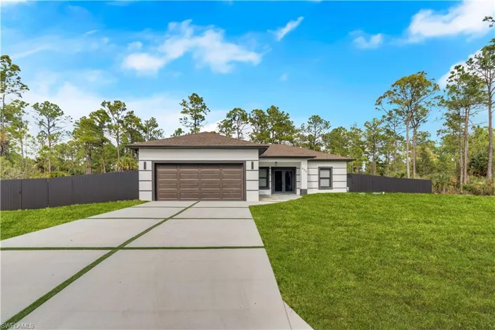 Prairie-style house with concrete driveway, an attached garage, stucco siding, and a shingled roof