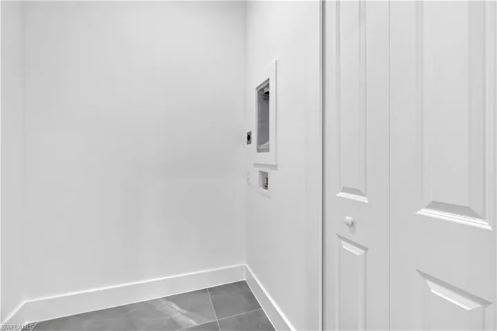 Laundry area featuring hookup for a washing machine and tile patterned flooring