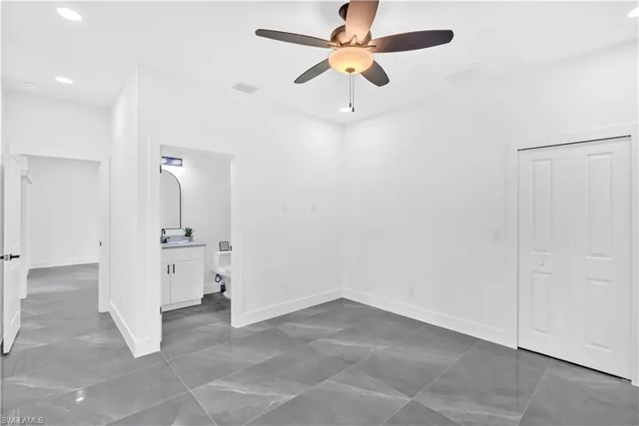 Unfurnished bedroom with recessed lighting, a ceiling fan, and connected bathroom