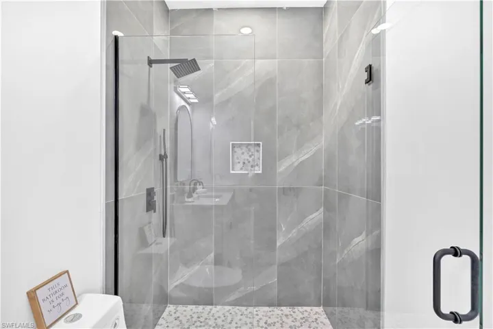 Full bathroom featuring a stall shower and toilet