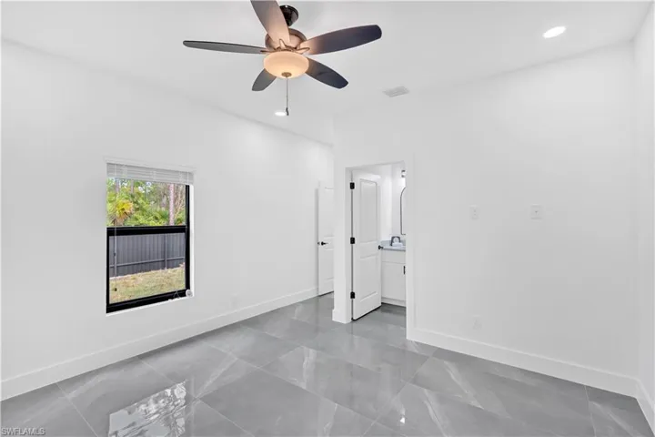 Unfurnished bedroom with recessed lighting, ceiling fan, and ensuite bathroom