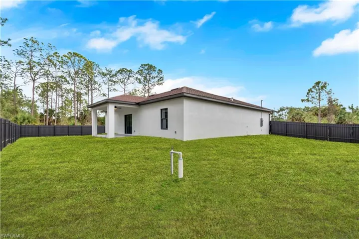 Rear view of house with a fenced backyard, a patio, and stucco siding