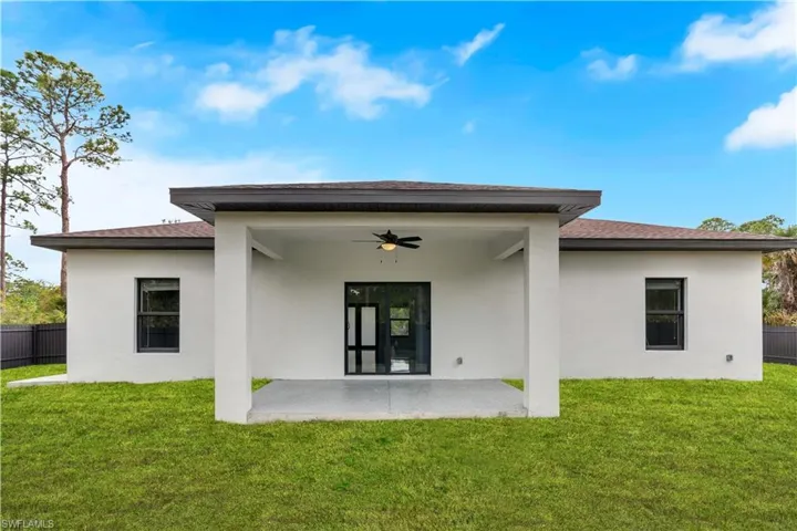 Back of house with a ceiling fan, a patio area, stucco siding, and roof with shingles