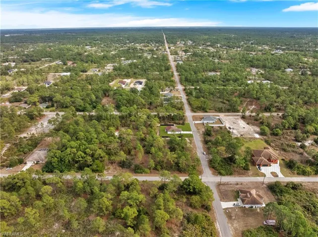 Aerial view of property and surrounding area with a heavily wooded area