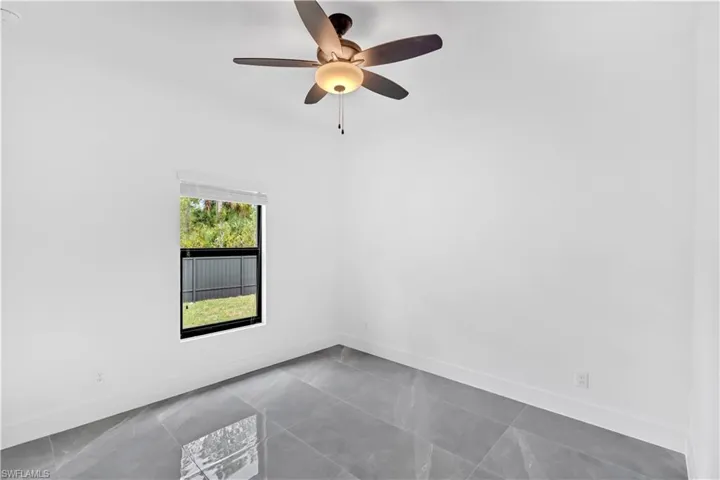 Spare room with baseboards and ceiling fan