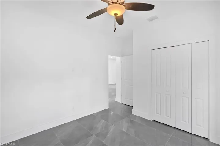 Unfurnished bedroom featuring a ceiling fan and a closet