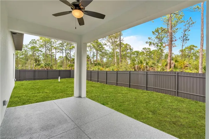 Fenced backyard featuring a patio and ceiling fan