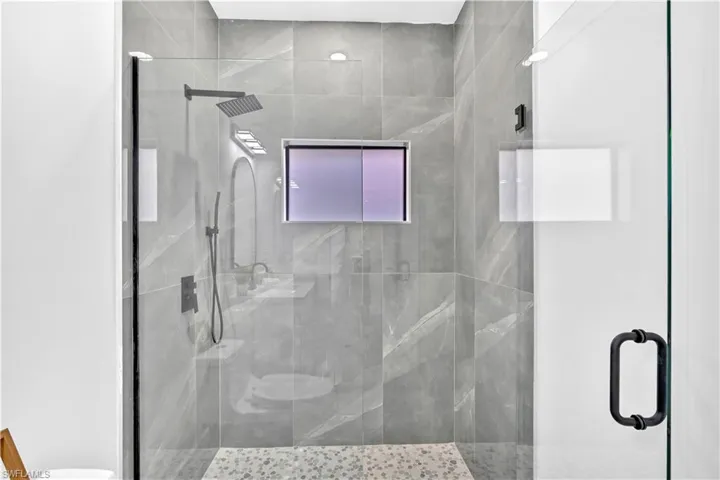 Full bathroom featuring a shower stall and toilet