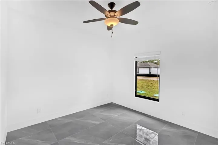 Unfurnished room with baseboards and a ceiling fan