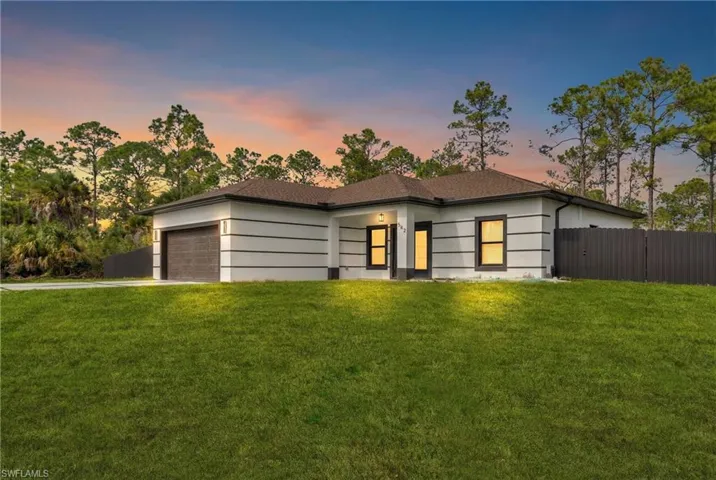 View of front of property featuring concrete driveway and an attached garage