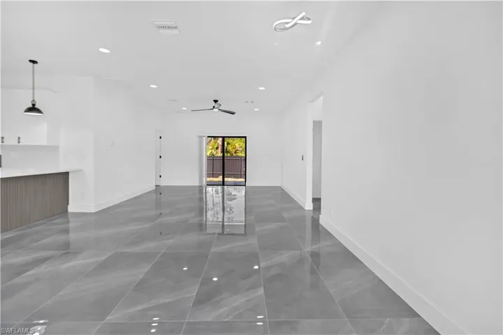 Unfurnished living room featuring recessed lighting and baseboards