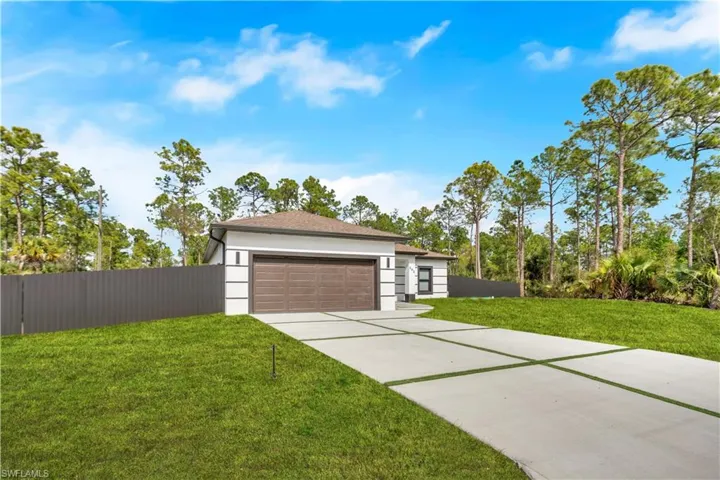 View of front of home with driveway, stucco siding, and a garage