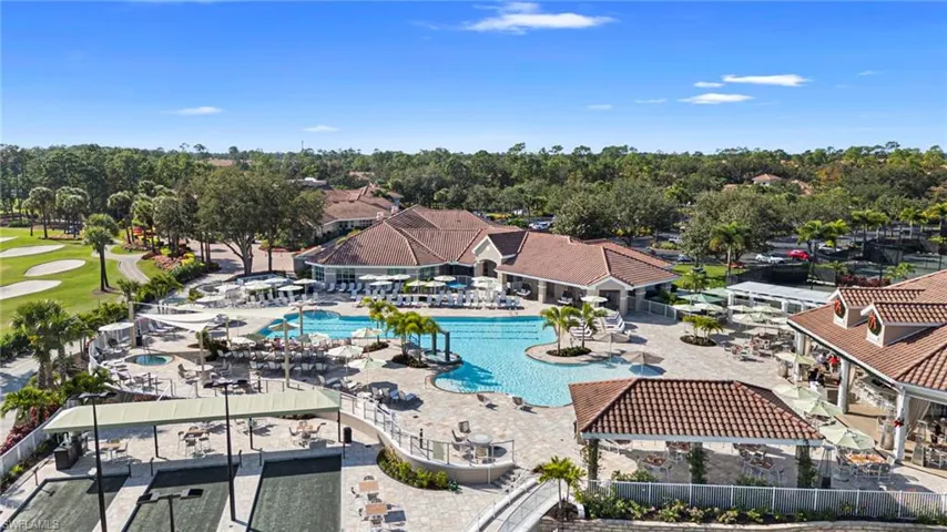 Recreational complex featuring a large swimming pool, multi-use hardscaping, covered pavilion structures with tile roofs, and marked sports courts