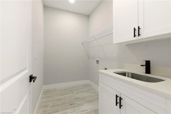 Laundry room featuring wood tiled floors, hookups for a washing machine, cabinet space, and recessed lighting