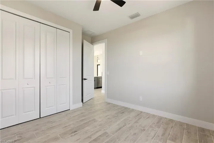 Unfurnished bedroom with a closet, wood tiled floors, and ceiling fan